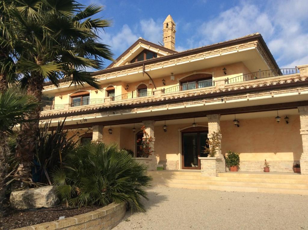 科隆内拉Villa Civita的前面有棕榈树的建筑