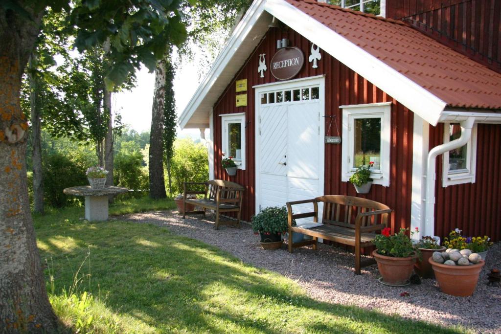 Bjällum霍尔波阿琼斯度假屋的坐在红色建筑外的长凳