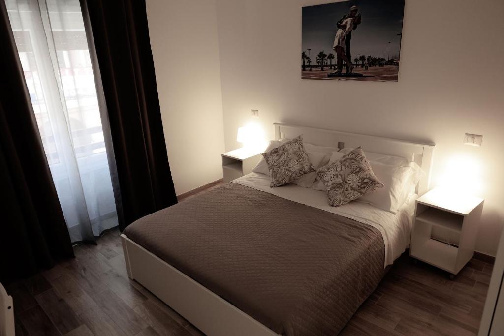 奇维塔韦基亚Central Guest House的一间卧室配有一张带2个床头柜和2盏灯的床。