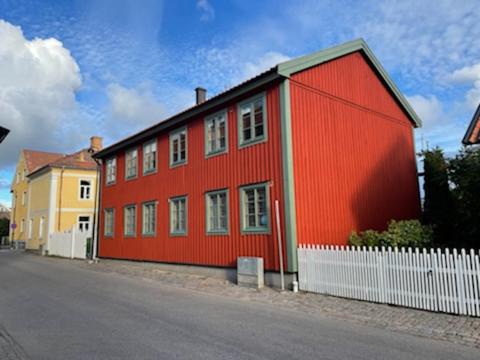 瓦斯泰纳Vadstena centrum的一条街道旁的红色建筑,有白色的栅栏