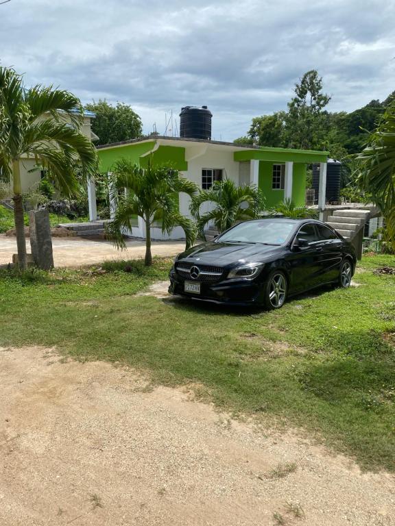 拉纳韦贝June’s comfort paradise的停在房子前面的一辆黑色汽车