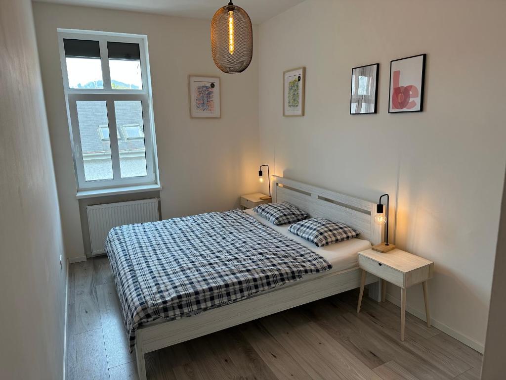 布拉迪斯拉发Lovely 2-bedroom apartment in centre of Bratislava的一间卧室配有一张床、两盏灯和一个窗户。