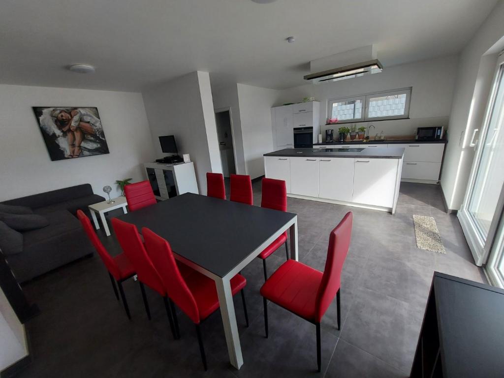 VichtenComfortable room with double bed的厨房以及带桌子和红色椅子的用餐室。
