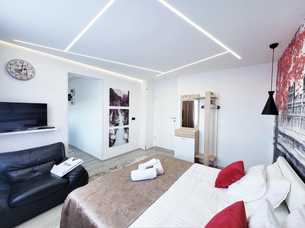 普里什蒂纳Cozy Apartment in Pristina的一间卧室配有一张大床和一张沙发