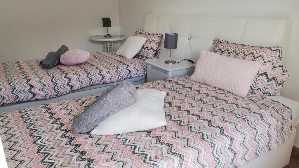 科武港Apartamentos Guiomar Campos的一间卧室配有两张带枕头的床。
