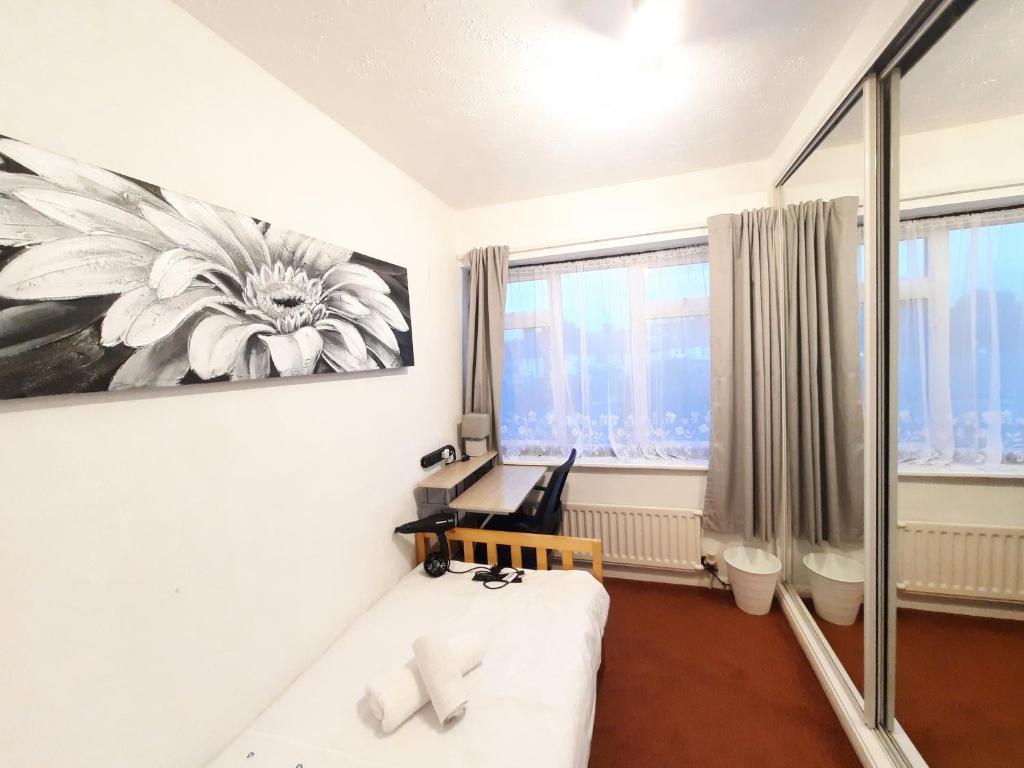 伦敦London North Downs rooms的一间设有白色沙发的客房,墙上挂有绘画作品