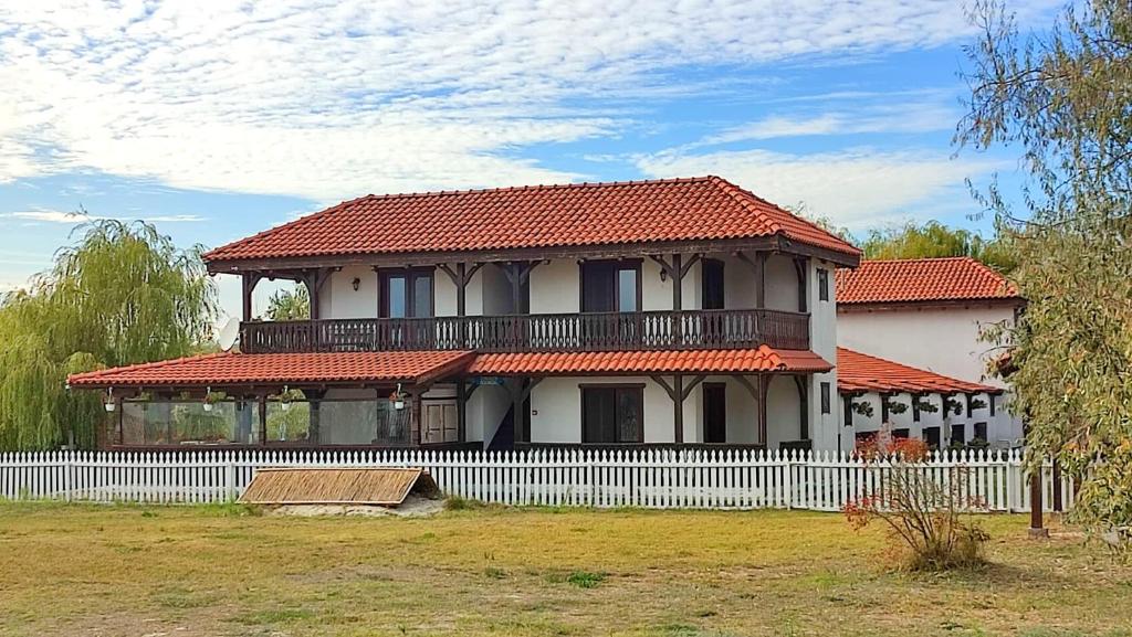 科尔布Casa Pescareasca - Complex Plaja Golf的白色围栏和红色屋顶的房子