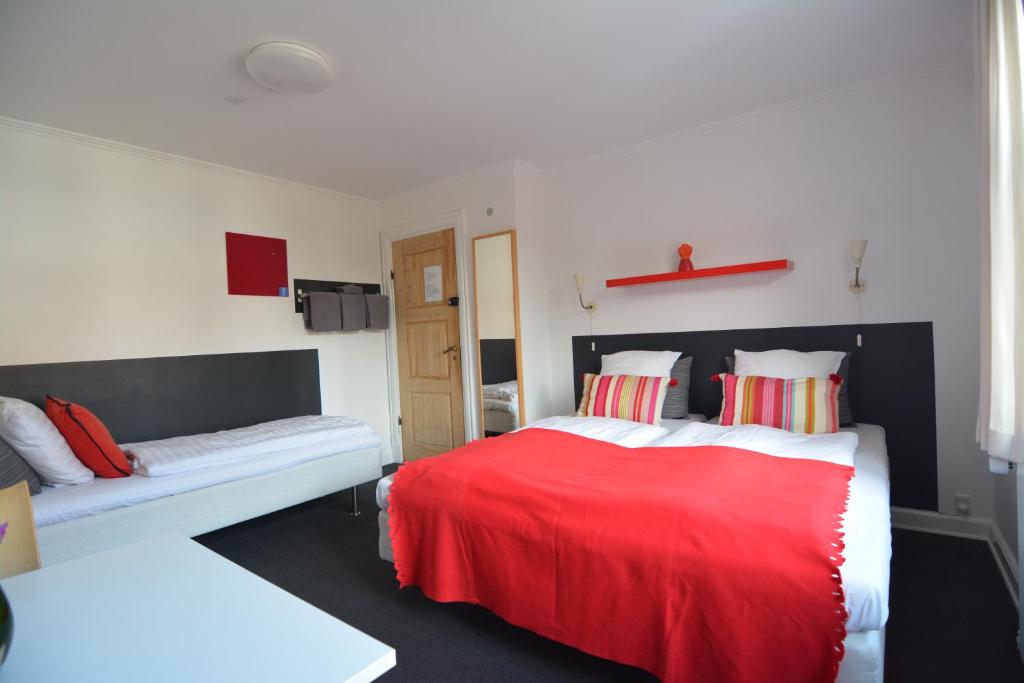 欧登塞Billesgade Rooms的卧室配有红色和白色的床和沙发