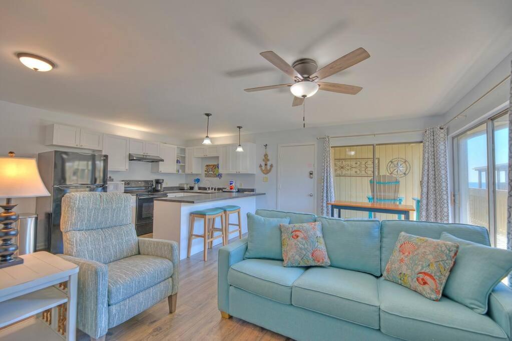 格尔夫海岸Living the Dream 2 Bedroom Ocean View Cozy Condo的一间带蓝色沙发的客厅和一间厨房