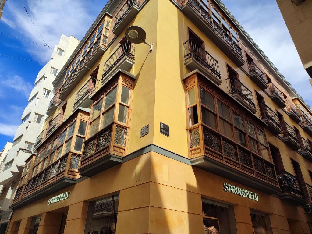 卡塔赫纳CARTAGENAFLATS, Apartamentos Calle Mayor, CITY CENTER的黄色的建筑,旁边设有阳台