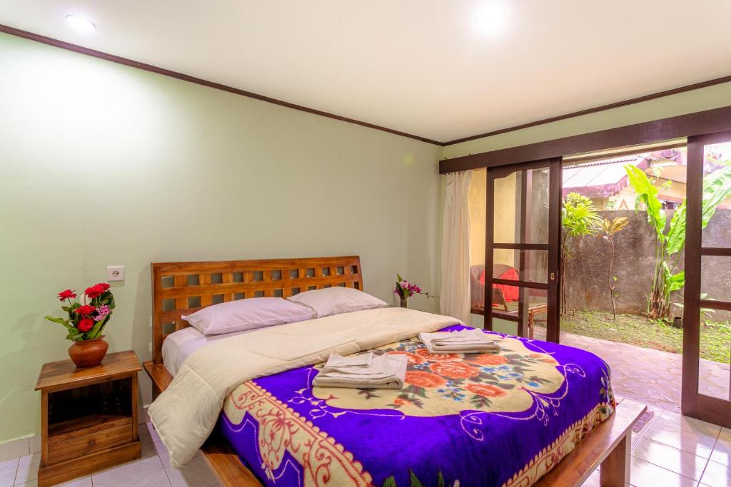 贝都古Pacung Indah Hotel & Restaurant by ecommerceloka的一间卧室配有一张大床和紫色毯子