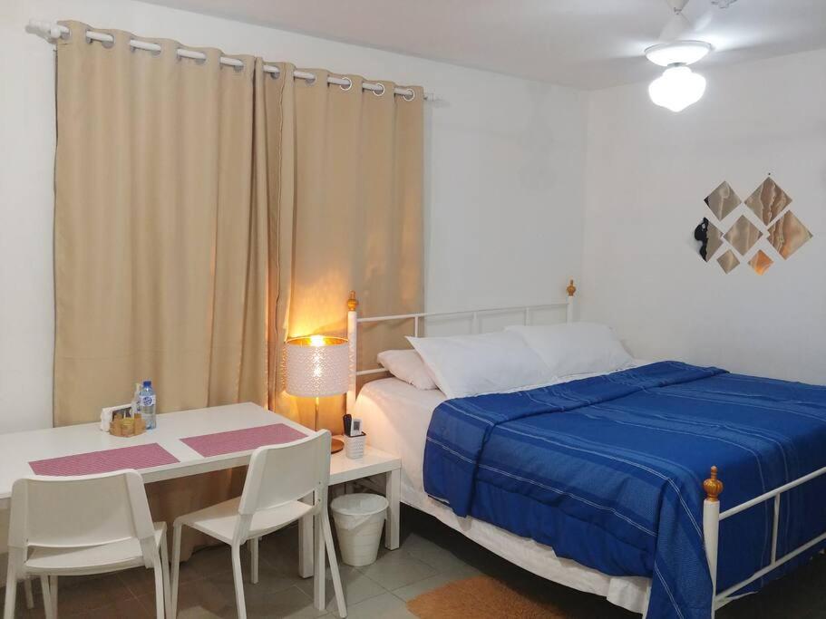 圣斐利-银港Dominican Suite 21, Amazing Apt/Studio (DS21)的卧室配有一张床和一张桌子及椅子
