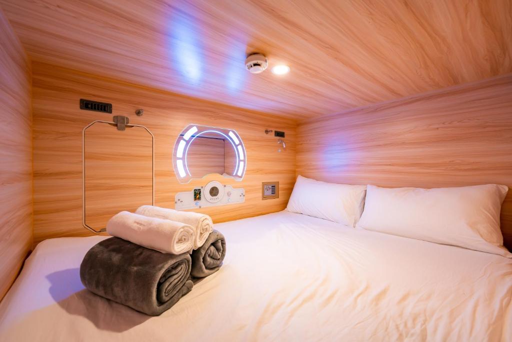 哥打京那巴鲁Jpod Capsule Hotel的一个小房间,配有一张床铺和摄像头