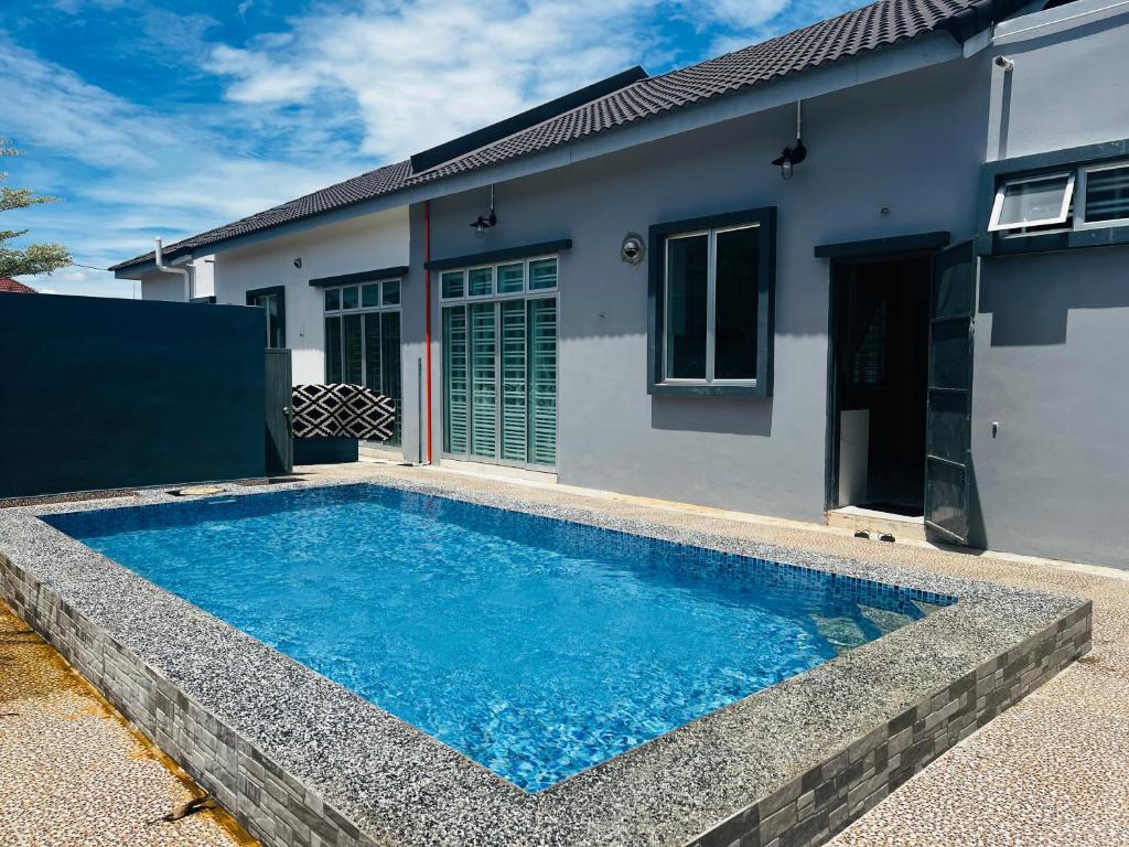 Kampong HilirVilla Pool Kepala Batas的房屋前的游泳池