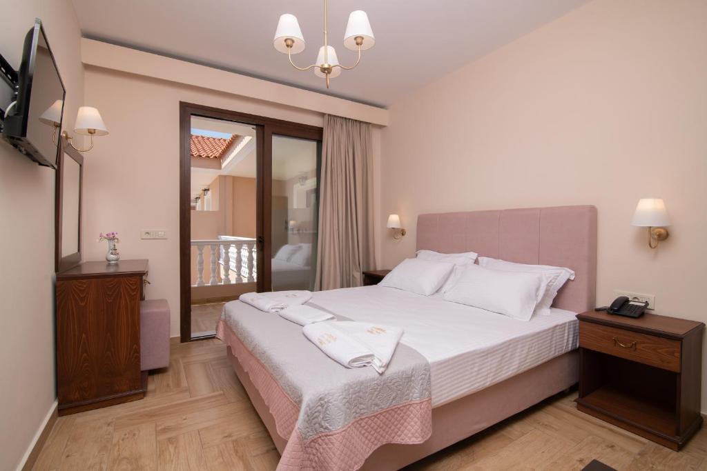 卡拉马孔Zante Holidays Hotel的卧室设有一张白色大床和一扇窗户。