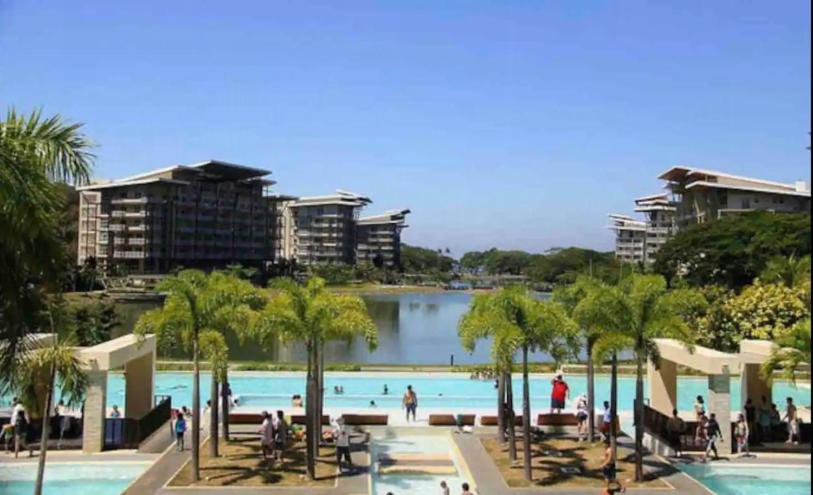 纳苏格布Cozy 2Bedroom Beach Condo with Lagoon View Balcony的棕榈树和水体的大型游泳池