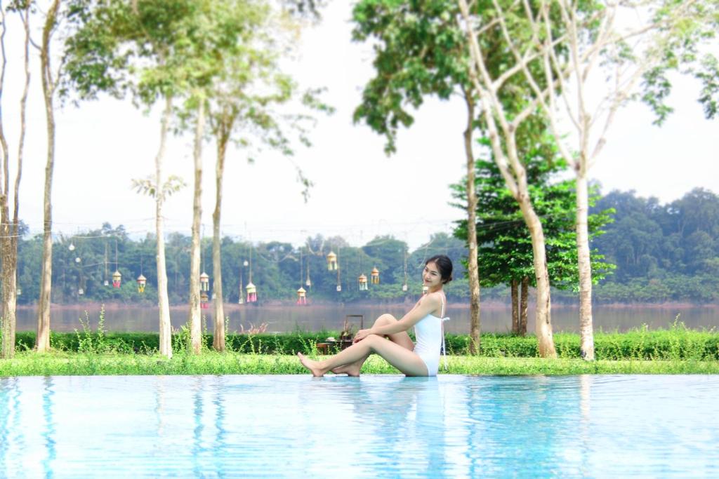 清刊River Tree Resort的坐在水边的女人