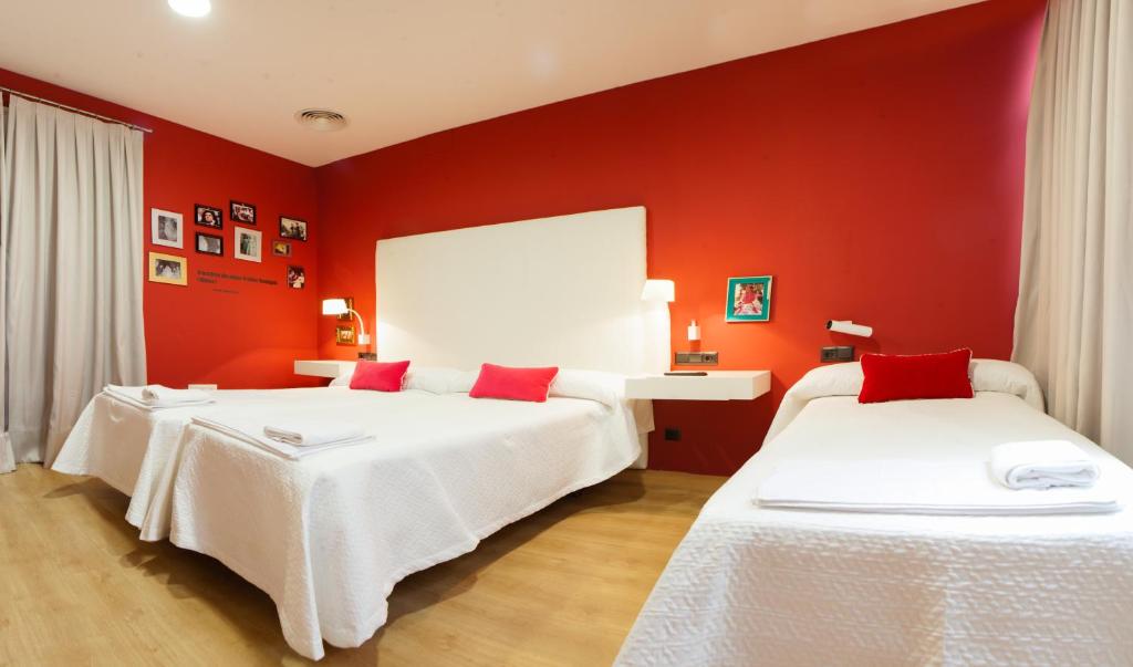 塞维利亚塞维利亚瑞充尔阿拉米达旅馆的红色墙壁客房的两张床