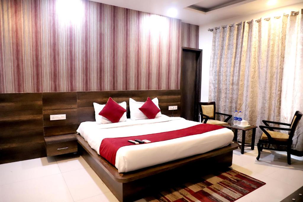阿姆利则Hotel Hollywood Heights的一间卧室配有一张带红色枕头的大床