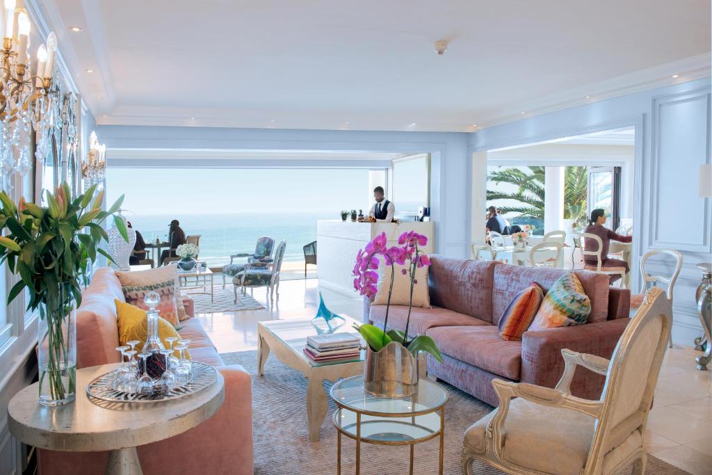 开普敦克拉伦登班特里湾酒店的客厅配有沙发和桌子,享有海景。