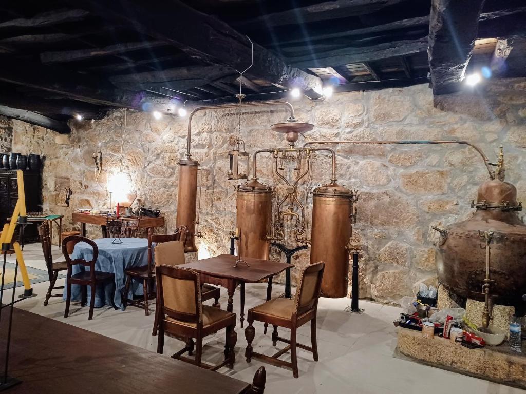 Casario do Vale Hospedagem e Eventos的一间设有桌椅和石墙的用餐室