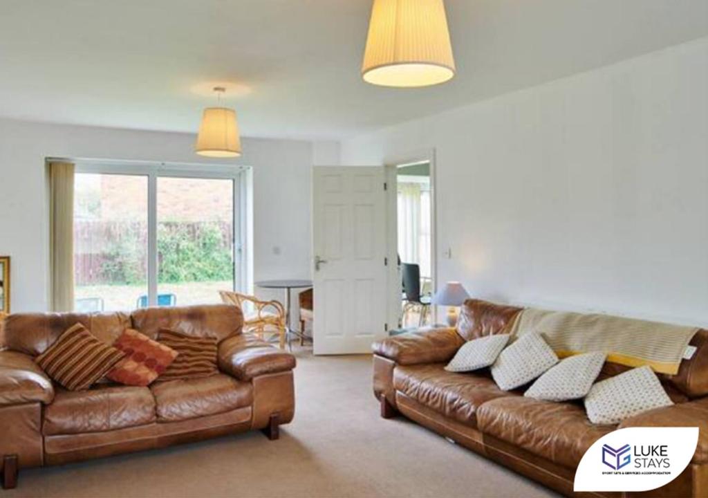 West CornforthLuke Stays - The Green的客厅配有2张棕色皮沙发