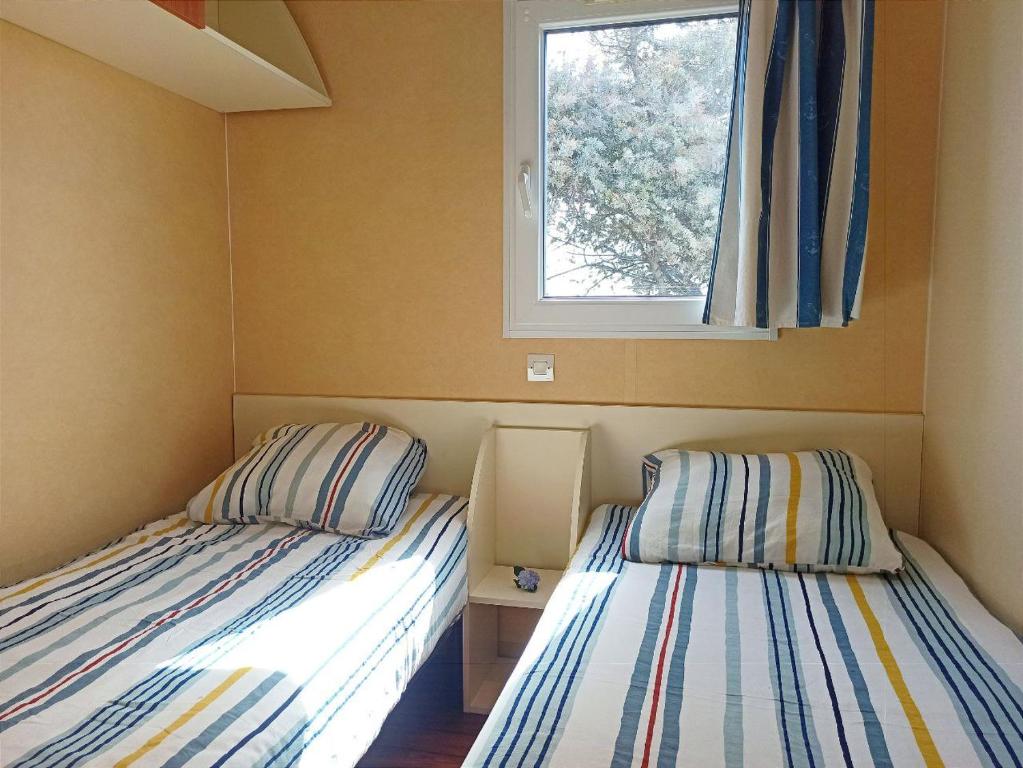 马佐Casitas Mobil Home的小型客房 - 带2张床和窗户