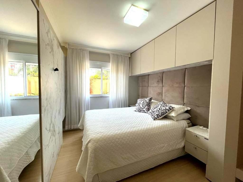 帕苏丰杜Apartamento Villa Nova Master Collection的一间卧室设有两张床和两个窗户。