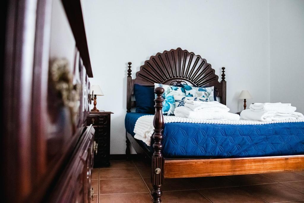 FeteiraApartamento Bela Vista Ilha Terceira的一间卧室配有一张带蓝色和白色枕头的床