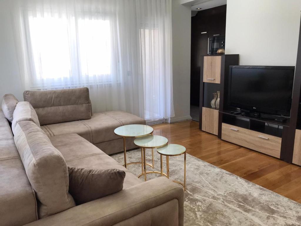 新帕扎尔Paradiso Apartment的客厅配有沙发和2张桌子