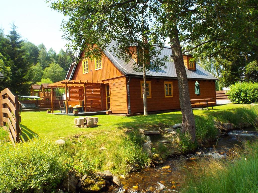 Stará VesCzech Lodge的小木屋前面有一条小溪