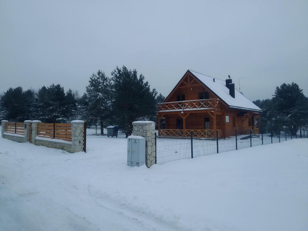 SygontkaChata Sosenka的雪中带围栏的小木屋