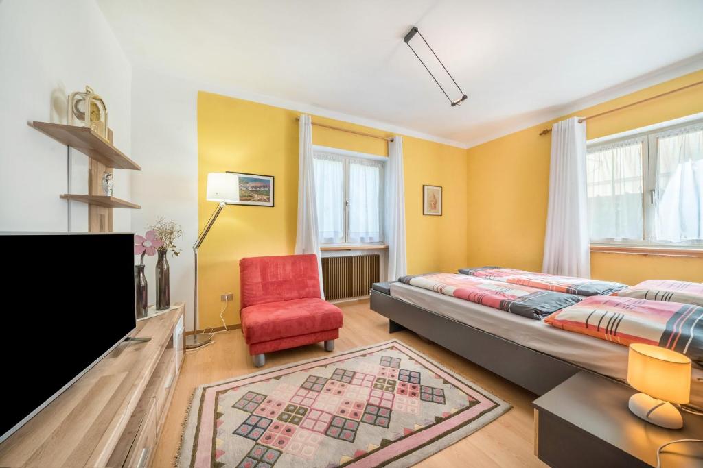 拉纳Apartement Oase的一间卧室配有一张床和一张红色椅子