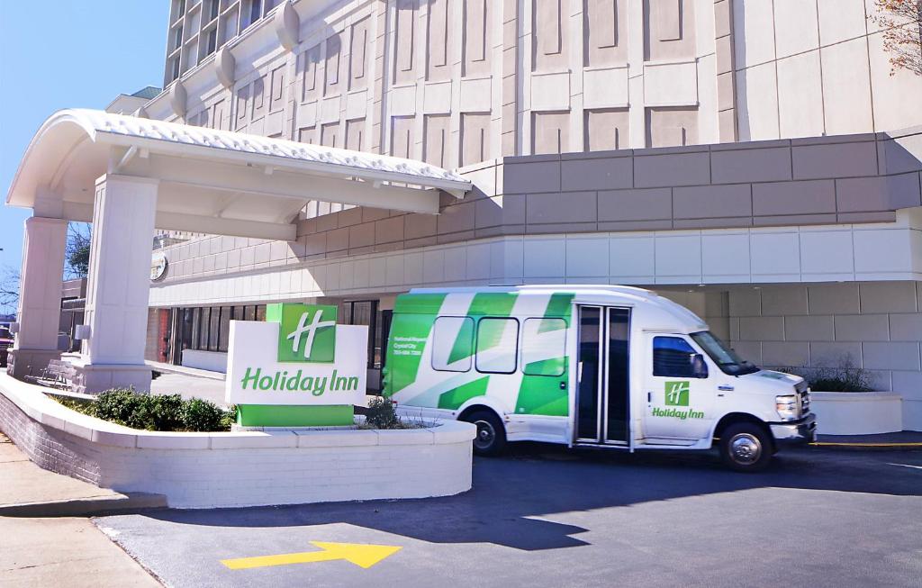 阿林顿Holiday Inn National Airport/Crystal City, an IHG Hotel的停在大楼前的一辆白色绿色货车