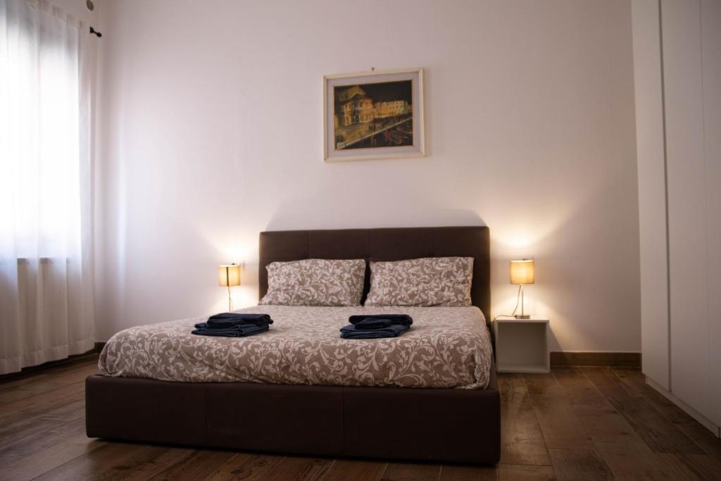 穆拉诺Beocio Home • The hidden gem in Murano’s heart的一间卧室配有一张带两盏灯的床。