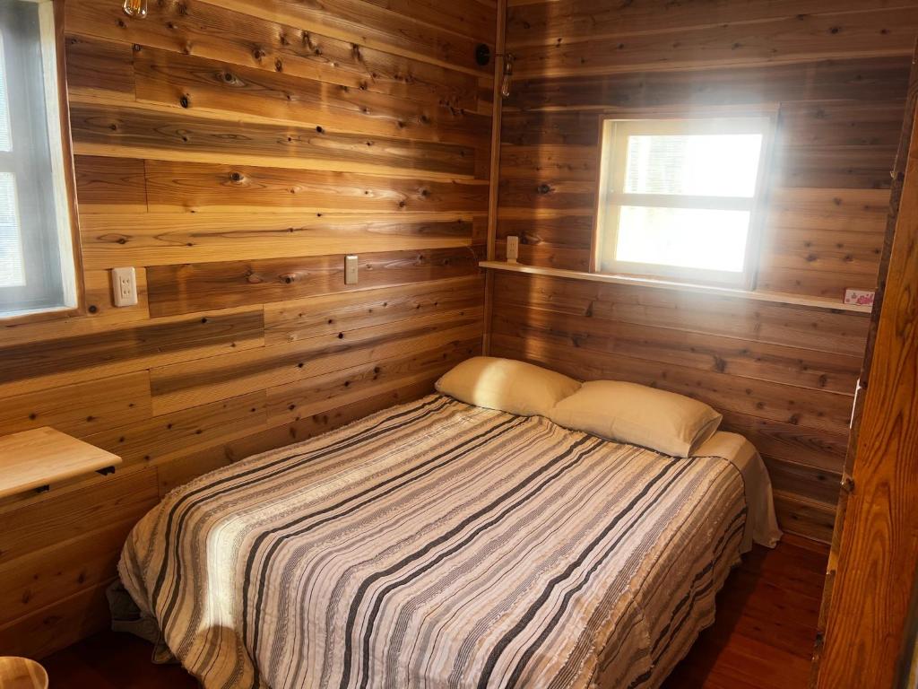 益城町Glamping Village Leaf - Vacation STAY 65726v的木制客房内的一间卧室,配有一张床