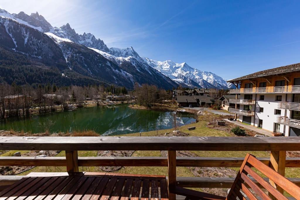 夏蒙尼-勃朗峰Modern 2BR 5* pool gym spa garage Mont-Blanc view的从带湖泊的度假胜地的阳台欣赏风景