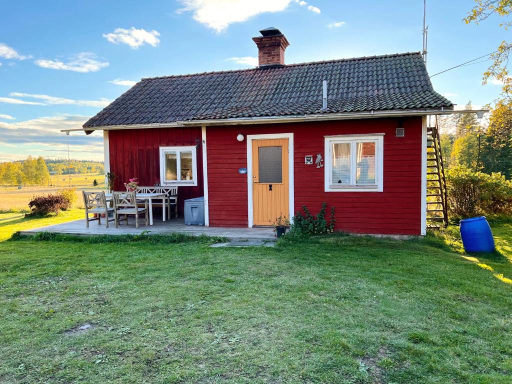 MöklintaAldermyran - 1800-talstorp i Möklinta的草坪上带桌子的红色房子
