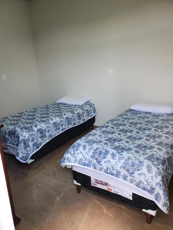 圣罗克迪米纳斯Apart-Hotel Canastra的两张睡床彼此相邻,位于一个房间里