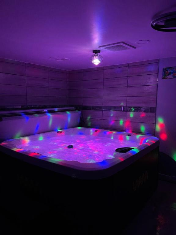 底特律Adults Only vacation rental with Hot tub- NO PARTIES的紫色的客房设有大浴缸及灯