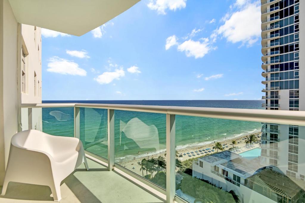 好莱坞THE TIDES 2bedrooms apt 14th floor WE ARE ON THE BEACH!的海景阳台和白色椅子。