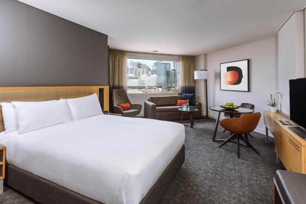 悉尼达令港诺富特悉尼酒店的酒店客房设有床和客厅。