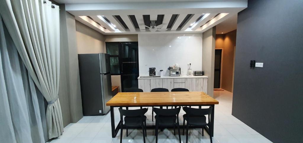 Kota SamarahanRegalia Apartment B-3-1 Kota Samarahan的厨房配有桌椅和冰箱。