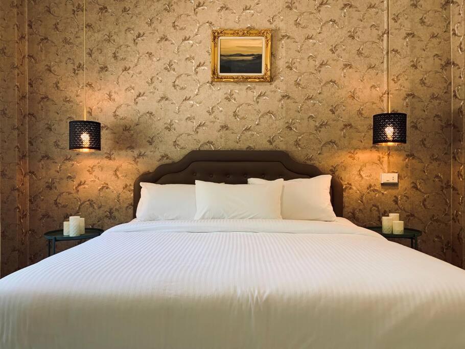 拉廊W house Ranong 2bedroom villa 8/9的一间卧室配有一张带两盏灯的大型白色床。
