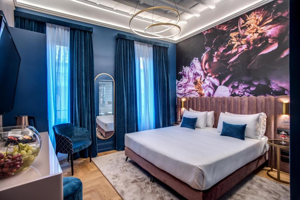 罗马Palazzetto Trevi的卧室配有一张床,墙上挂有绘画作品