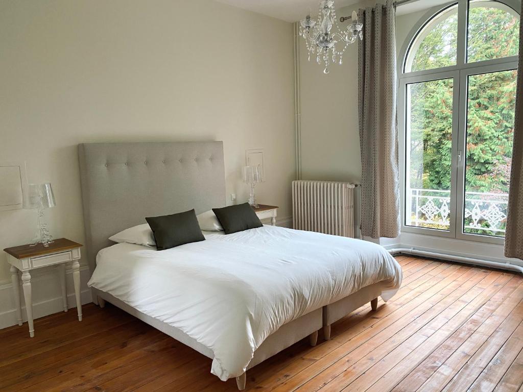 Bonneuil-les-EauxDomaine de Bonneuil的卧室设有一张白色大床和大窗户