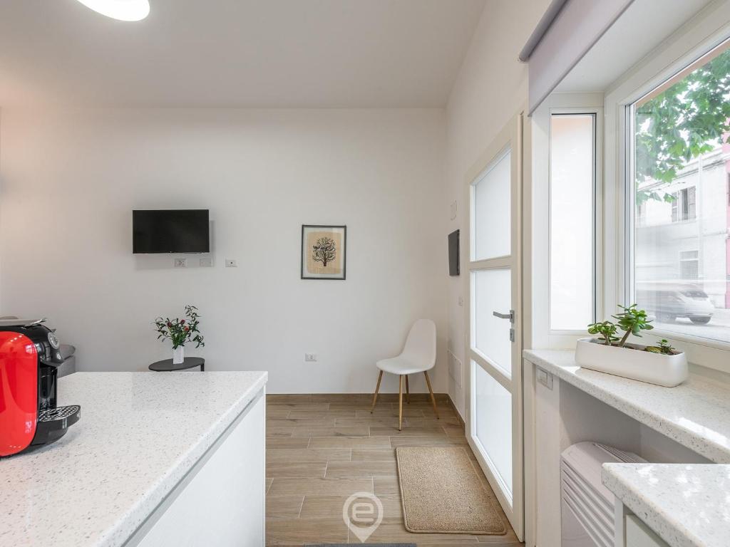 奥里斯塔诺Casa Aura - City Centre的白色的厨房配有书桌和窗户