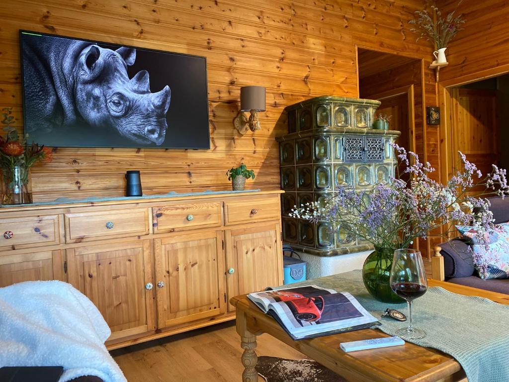 奥森富尔特My Happy Garden 1500sq m的客厅设有木墙,配有电视。