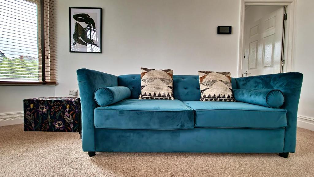 卡迪夫Thompson Apartments by Switchback Stays的客厅配有带枕头的蓝色沙发