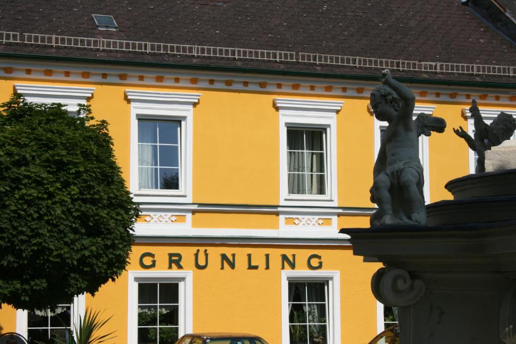 Wallsee格灵酒店的前面有雕像的黄色建筑